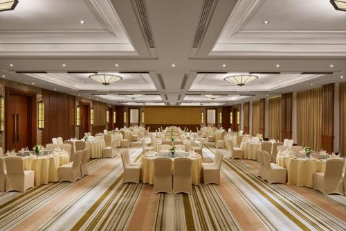 a large banquet hall with white tables and chairs at InterContinental Xishuangbanna Resort by IHG in Jinghong