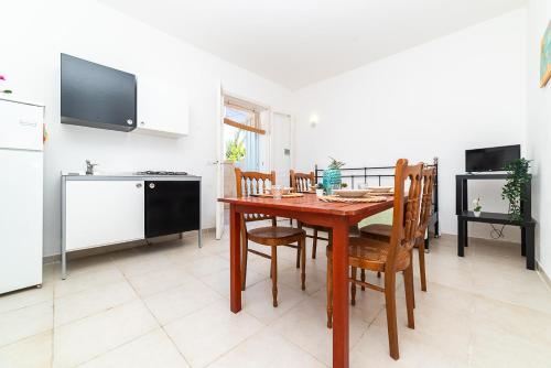 a kitchen and dining room with a wooden table and chairs at Casa degli Oleandri in Ostuni