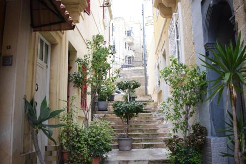 an alley with stairs with potted plants at Cottonera Lines Boutique Holiday Accomodation in Cospicua