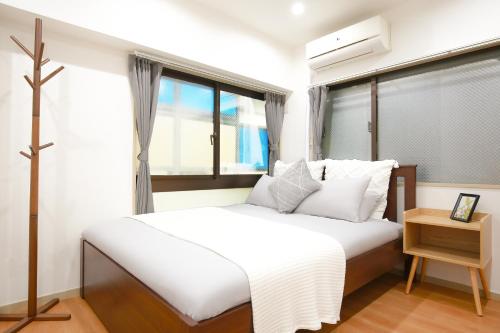 a bedroom with a white bed and a window at 銀座線すぐ近く 歴史寺院巡りに最適 松が谷の静かな一軒家 Sio1g in Tokyo