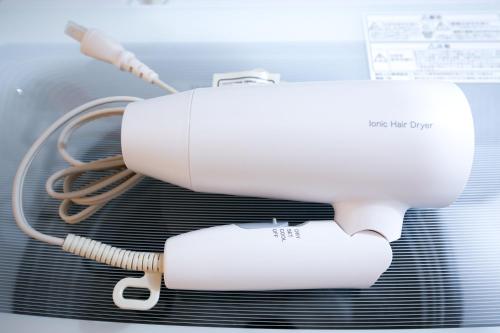 a white hair dryer sitting on top of a machine at 銀座線すぐ近く 歴史寺院巡りに最適 松が谷の静かな一軒家 Sio1g in Tokyo