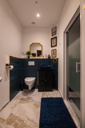 une salle de bain avec toilettes et miroir dans l'établissement Suite Prohibition - Love & atypique room sauna & spa, à Issoudun