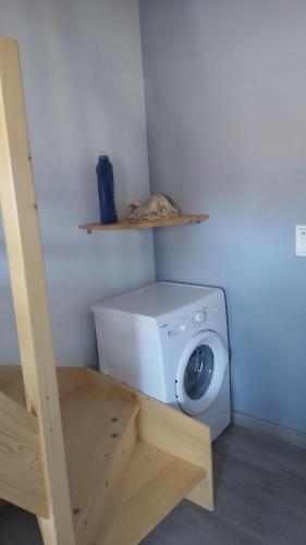 a laundry room with a washing machine and a shelf at La Crozat in Giez