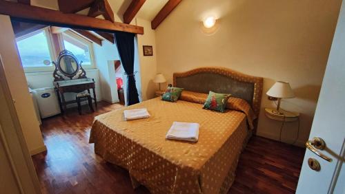 a bedroom with a bed with two towels on it at Scarlet Flower - Lago Maggiore in Meina
