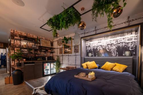 a bedroom with a large blue bed with yellow pillows at Suite Prohibition - Love & atypique room sauna & spa in Issoudun
