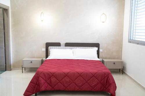 a bedroom with a red bed with two night stands at Pietra Viva Suite e Relax in Veglie