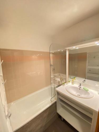 une salle de bain avec une baignoire et un lavabo et une baignoire dans l'établissement Seven Keys - Ecrin Savoyard, à Valmeinier