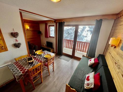 ein Wohnzimmer mit einem Tisch und einem Sofa in der Unterkunft Seven Keys - Ecrin Savoyard in Valmeinier
