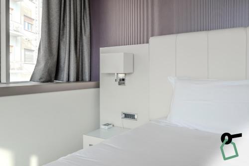 a bedroom with a white bed and a window at HOTIDAY Room Collection - Trapani in Trapani