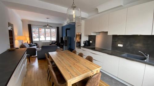Il comprend une cuisine et un salon avec une table en bois. dans l'établissement Maison Féli', à Bourg-Saint-Maurice