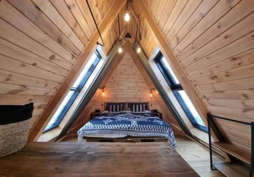 a bedroom in a attic with a bed in it at Dakota forest retreat in Tsigov Chark