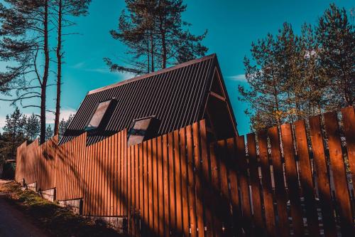 a wooden fence with a house behind it at Dakota forest retreat in Tsigov Chark