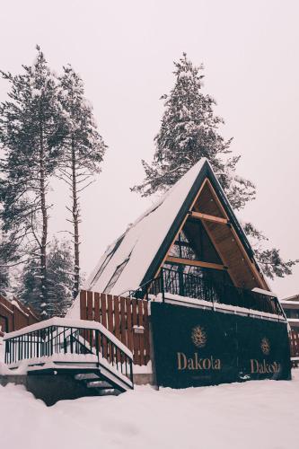 a cabin with a snow covered roof in the snow at Dakota forest retreat in Tsigov Chark