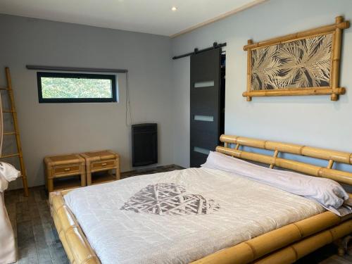 - une chambre avec un lit avec un cadre en bois et une fenêtre dans l'établissement Maison atypique - lisière de forêt - Bassin Arcachon, à Audenge
