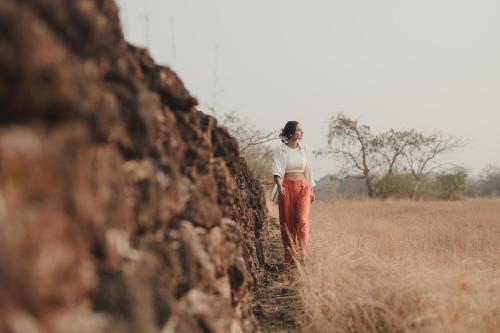 a woman standing in a field near a wall at Brij Paraiso Saligao, Goa - An Indo-Portuguese Villa in Calangute