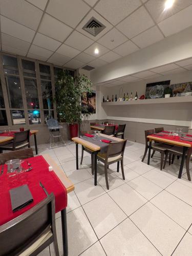 a dining room with tables and chairs in a restaurant at KYRIAD ORANGE Centre Ville - HOTEL & RESTAURANT & BAR - La Galerie d'Art des Princes - Provence Alpes Côte d'Azur - France - Proche A7-A9 - exit21- Châteauneuf-du-Pape Avignon Bollene Nimes - 24h-24h in Orange