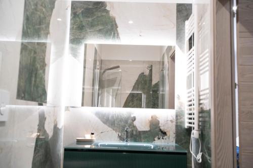 a bathroom with a sink and a mirror at Pietra Viva Suite e Relax in Veglie