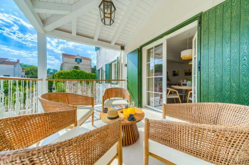 a porch with wicker chairs and a table with drinks on it at Hotel Brattia, Adults Only, Heated Pool, A la Carte Breakfast, Postira, Brač Island in Postira