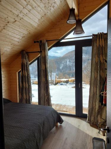 a bedroom with a bed and a large window at Green Kub in Slănic-Moldova