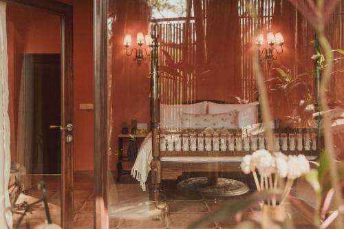 a room with a bench in a room with red walls at Brij Paraiso Saligao, Goa - An Indo-Portuguese Villa in Calangute