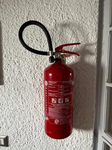 a red fire hydrant is attached to a wall at BOUGANVILLE casa vacanza ambiente climatizzato con wi fi in Pineto