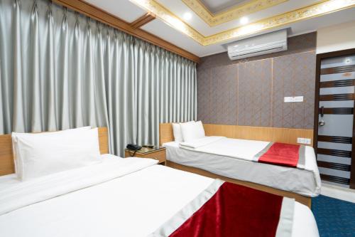 a hotel room with two beds and a window at Hotel Safa Residency - DHAKA in Dhaka