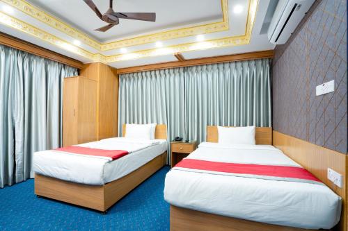 two beds in a hotel room with curtains at Hotel Safa Residency - DHAKA in Dhaka