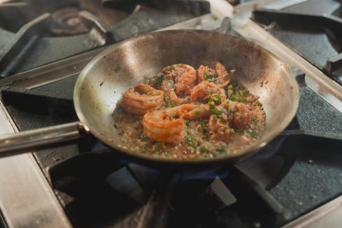 a pan with shrimp cooking on a stove at Brij Paraiso Saligao, Goa - An Indo-Portuguese Villa in Calangute