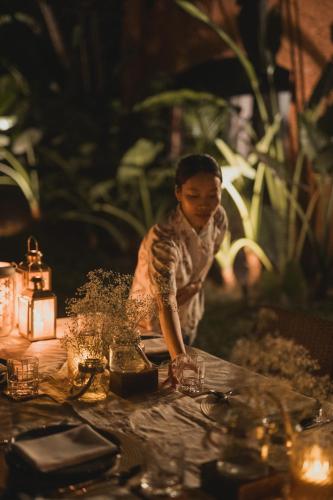 a woman standing in front of a table with lights at Brij Paraiso Saligao, Goa - An Indo-Portuguese Villa in Calangute