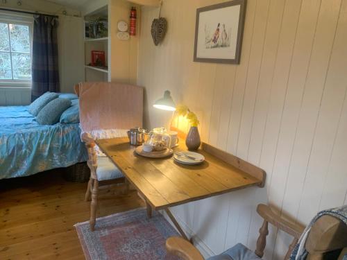 a room with a table with a bed and a table sidx sidx sidx at Phoenix Farm Shepherds Hut,Minions, Cornwall in Liskeard