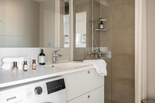 a bathroom with a sink and a washing machine at Clover House by Daniel&Jacob's in Copenhagen