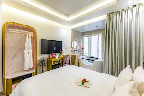 a bedroom with a white bed and a television at Mai Hotel in Hanoi