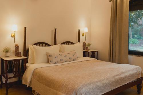 a bedroom with a large bed with pillows and a window at Brij Paraiso Saligao, Goa - An Indo-Portuguese Villa in Calangute