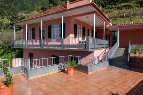a house with a balcony and a patio at Domingos House - Valley View in Boaventura