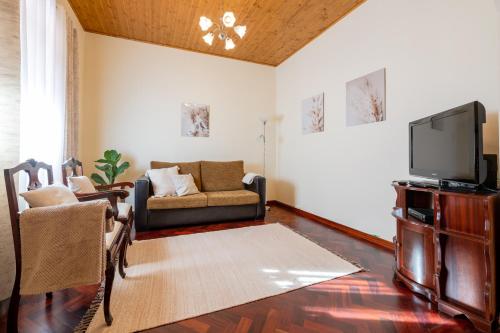 a living room with a couch and a tv at Domingos House - Valley View in Boaventura