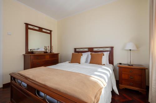 a bedroom with a large bed and a mirror at Domingos House - Valley View in Boaventura