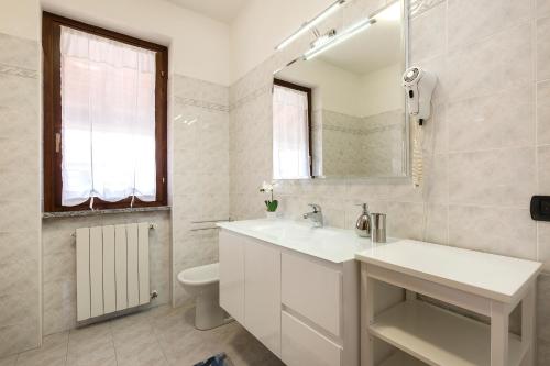 bagno con lavandino, servizi igienici e specchio di Casa Allegra a Orta San Giulio