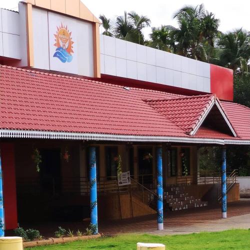 a red roofed building with a red roof at Ashirvad Villa Rooms in Kotikulam