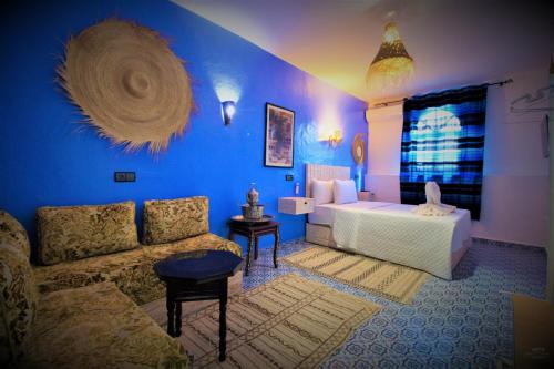 a blue living room with a couch and a bed at CASA TROUSSI in Chefchaouene