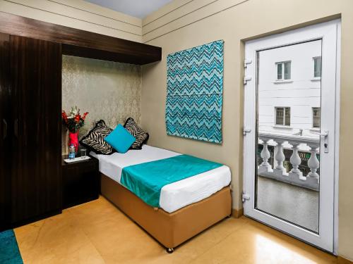 a bedroom with a bed and a sliding glass door at Hotel Ajanta - Colonial Charm Award Winning Luxury Hotel in the Heart of the City in New Delhi