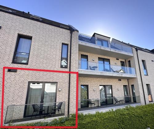 a brick building with black chairs in front of it at 4Hafenzeiten - NIE3 Möve in Niendorf