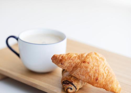 a croissant and a cup of coffee on a tray at Pietra Viva Suite e Relax in Veglie