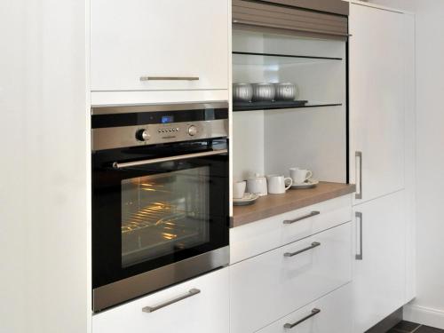 a kitchen with white cabinets and an oven at Ferienwohnung Bock Feldmannshof in Drolshagen