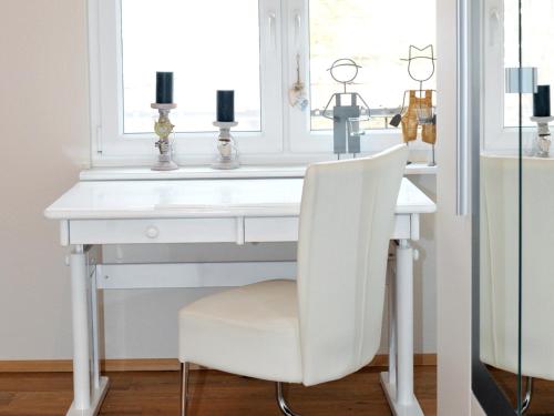 a white desk with a white chair in front of a window at Ferienwohnung Bock Feldmannshof in Drolshagen