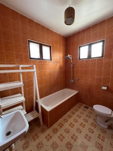 ジャンビアニにあるVilla Ivy Jambiani Zanzibarの浴槽、トイレ、洗面台を備えたバスルーム