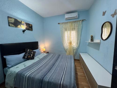 niebieska sypialnia z łóżkiem i oknem w obiekcie Apartment la paz w Madrycie