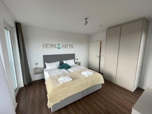 a bedroom with a large bed with two towels on it at Ferienappartement "Liegeplatz" in Sassnitz