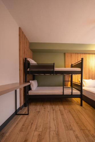 a room with three bunk beds and a wooden floor at Polek Hotel in Canakkale