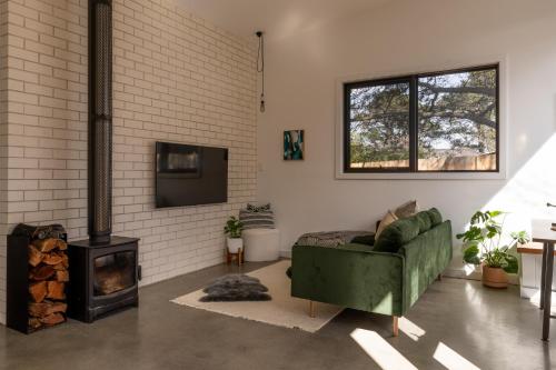 a living room with a green couch and a fireplace at Casa Mia Blackheath in Blackheath