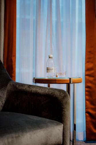 a table with a bottle on it next to a chair at Hyatt Regency London Albert Embankment in London